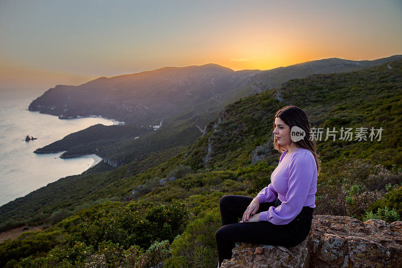 一位女士在Portinho da欣赏日落Arrábida